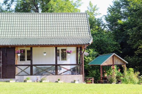 ein kleines Haus mit einem Pavillon auf einem Feld in der Unterkunft Котедж "Гірський Затишок" in Jaremtsche