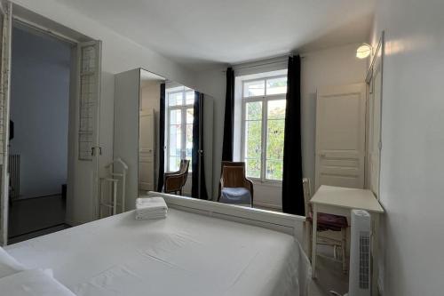 une chambre avec un lit et un grand miroir dans l'établissement La Savinienne de Cassis- 5mn port plage face mer, à Cassis