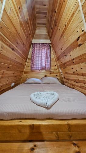 a bed in a log cabin with a window at Peaks of Prokletije - Outdoor pool in Gusinje