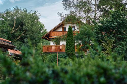 a tree house with a deck in the woods at Öko-Park Panzió, Kemping és Rendezvényközpont in Szarvaskő