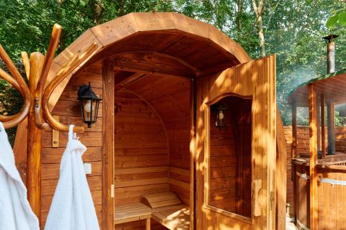 a wooden sauna with a towel hanging on the door at Öko-Park Panzió, Kemping és Rendezvényközpont in Szarvaskő