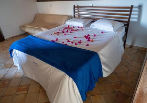 a bed with pink rose petals on it at Casa Paraiso in Maxaranguape