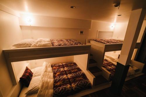 THE BEDFORD LODGE في إيزوميسانو: سريرين بطابقين في غرفة بسريرين