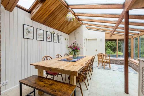 uma sala de jantar com uma mesa de madeira e cadeiras em Shannobank farmhouse em Duns