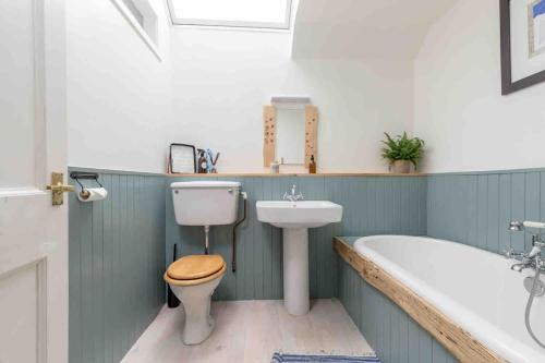 een badkamer met een toilet, een wastafel en een bad bij Shannobank farmhouse in Duns