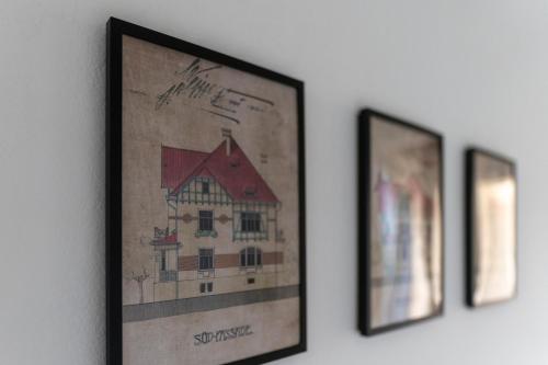 three framed pictures of a house on a wall at Vila Heide in Česká Kamenice