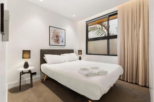 - une chambre avec un lit blanc et une fenêtre dans l'établissement THE SHORE: COOGEE BEACH, à Sydney