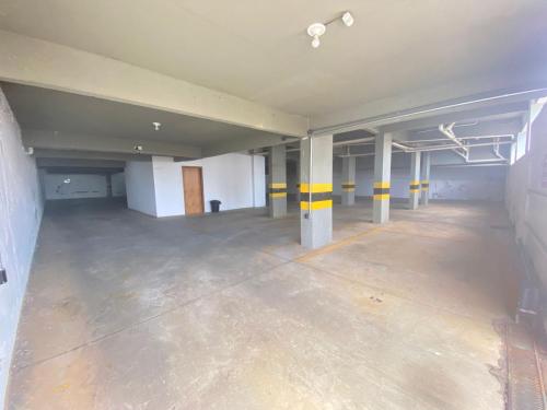 a large empty parking garage with yellow and white columns at Hotel Rota Do Sol in Patrocínio