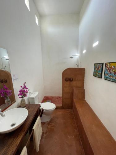 a bathroom with a sink and a toilet and a tub at Pangani Cliffs Lodge in Pangani