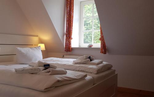 Strandperle Herrenhof في Wrixum: سريرين في غرفة نوم مع نافذة
