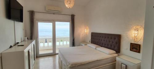 a bedroom with a bed with a view of the ocean at Beach House El Saladillo in Estepona