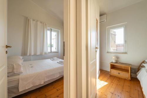 Habitación blanca con cama y ventana en Villa Cesira, en SantʼAndrea