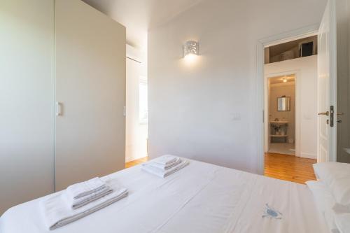 1 dormitorio con cama blanca y espejo en Villa Cesira, en SantʼAndrea