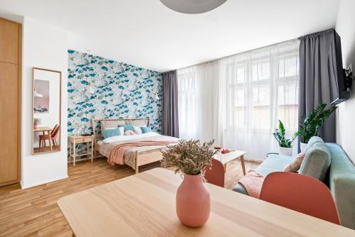 una habitación con una cama y un jarrón sobre una mesa en Enjoy Downtown Boutique Apartments #13 by Goodnite cz en Brno