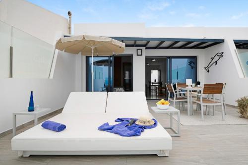 a bedroom with a white bed and an umbrella at Callao Beach 8 in Arrieta