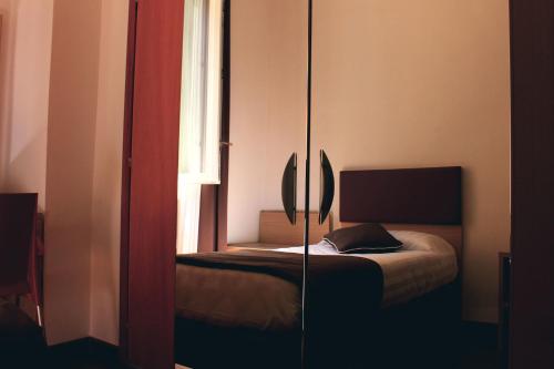 a bedroom with a bed and a mirror at Hotel Esperanza in Florence