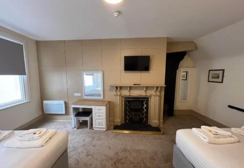 a living room with two beds and a fireplace at Talbot Hotel in Stourbridge