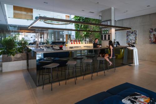 a woman sitting at a bar in a building at Posia Retreat & Spa UNA Esperienze in San Foca