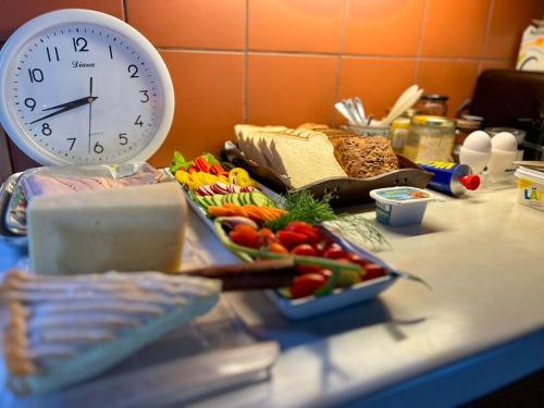 a clock sitting on top of a counter with vegetables at Egen stuga med delat badrum in Norrtälje