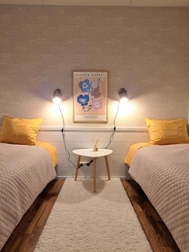 a room with two beds and a table with lamps at Ellivuori Resort Hehku 2 in Sastamala