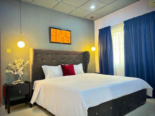 a bedroom with a large bed with blue curtains at The Orange Door Annex 2 in Lekki