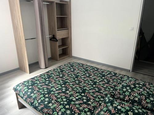 1 dormitorio con 1 cama con alfombra floral en el suelo en La Maisonnette, en Vendeuvre-sur-Barse