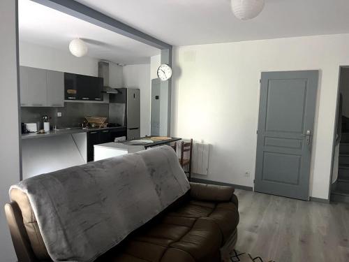 sala de estar con sofá y cocina en La Maisonnette, en Vendeuvre-sur-Barse