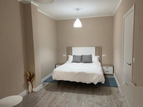 a bedroom with a large white bed in a room at Apartamento Vila de Neda in Neda