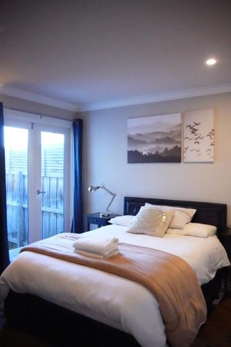 1 dormitorio con 1 cama grande con sábanas blancas en Cozy BoxHill - Modern Stylish Share House, en Box Hill