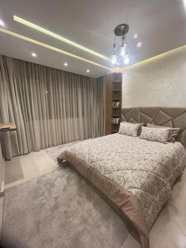 a bedroom with a large bed in a room at bon vivant, calme, famille, équipé, clim, TV, parking, parc, agadir, 7 personnes, stylé, wifi portable in Agadir