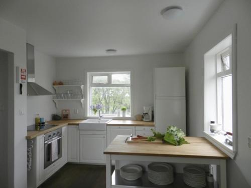 a kitchen with white cabinets and a wooden counter top at Farmhouse Meiri-Tunga 1 in Hella