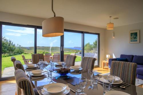 a dining room with a table and chairs at Locholly Lodge in Achiltibuie