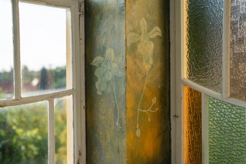 a room with two windows and a curtain with a painting at Vila Heide in Česká Kamenice