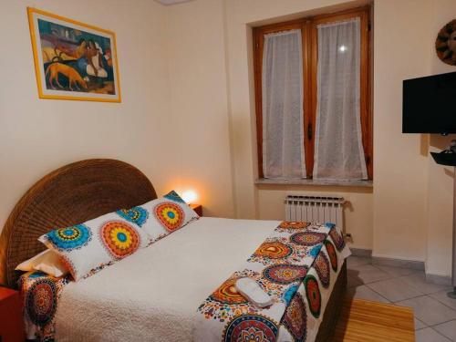 1 dormitorio con cama con almohadas y ventana en La Casa del Mondo en Turín