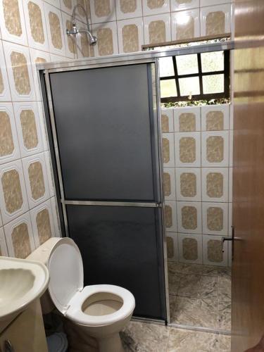 a bathroom with a toilet and a shower and a sink at Chácara espaçosa e aconchegante em Juquitiba Sp in Juquitiba