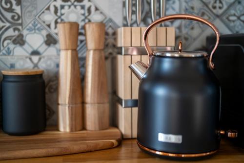 a black tea kettle sitting on a table next to a group of bats at Vila Heide in Česká Kamenice