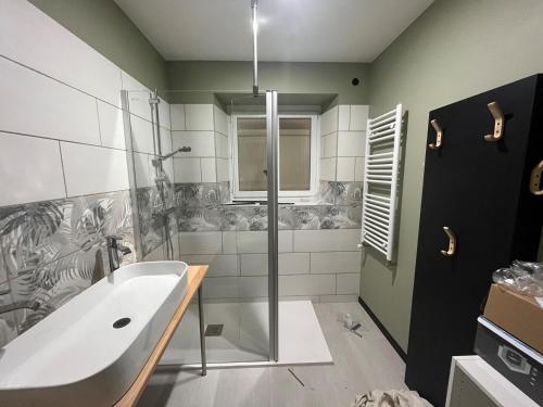 ein Badezimmer mit einer großen Badewanne und einer Dusche in der Unterkunft Gite sublime campagne in La Baconnière