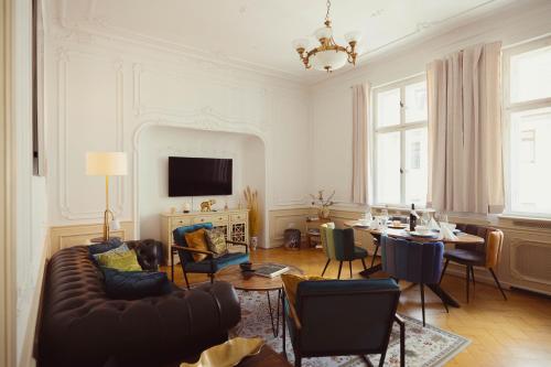 - un salon avec un canapé, une table et des chaises dans l'établissement Exklusive Ferienwohnung Arthur, à Zeitz