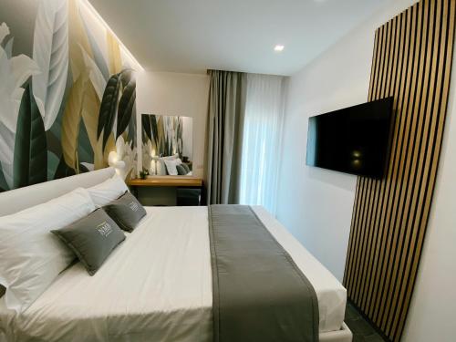 a bedroom with a bed with a flat screen tv on the wall at Naxos Marina Bay in Giardini Naxos