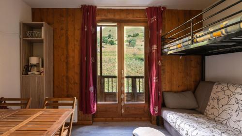 Habitación con litera, sofá y ventana en Les Ecureuils B11 - Studio montagne 2 pers en Saint-Sorlin-dʼArves