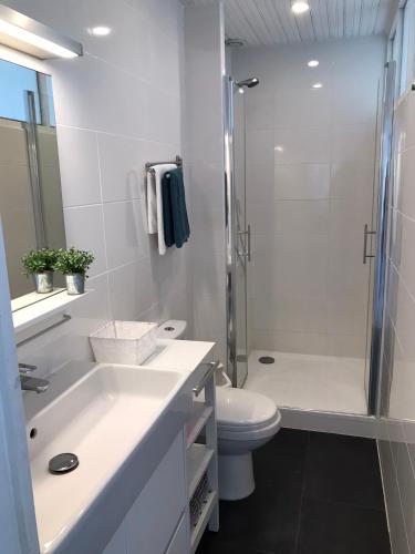 une salle de bain blanche avec douche et toilettes dans l'établissement La Gardinière, à La Barre-de-Monts