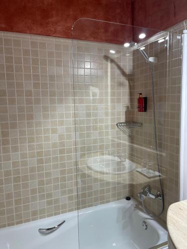 a bathroom with a shower with a tub and a sink at Hotel Rural Cazorla Posada del Cordobés in Cazorla
