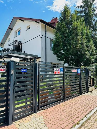 a black fence in front of a house at Apartamenty Pokoje Willa Bielany in Warsaw