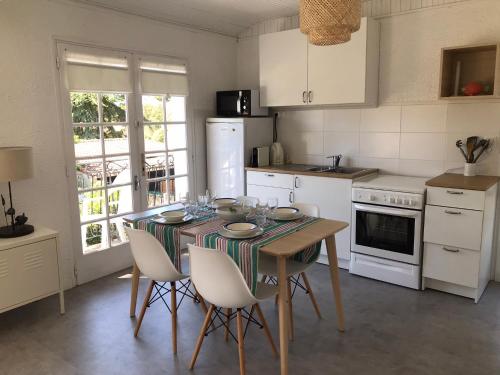 a kitchen with a table with chairs and a table and a table at La Gardinière in La Barre-de-Monts