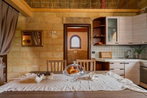 eine Küche mit einem Tisch mit einer Schüssel Essen drauf in der Unterkunft Dimora Soleda in Torre San Giovanni Ugento