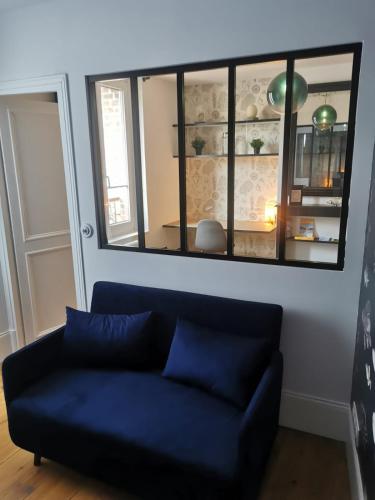 un canapé bleu dans un salon avec un miroir dans l'établissement Gîte le Beluga - proche mer - Veules-les-Roses, à Veules-les-Roses