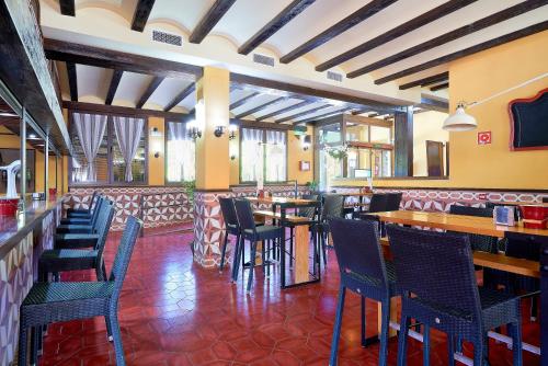 un restaurante con sillas y mesas y un bar en Hotel Rural Cazorla Posada del Cordobés en Cazorla