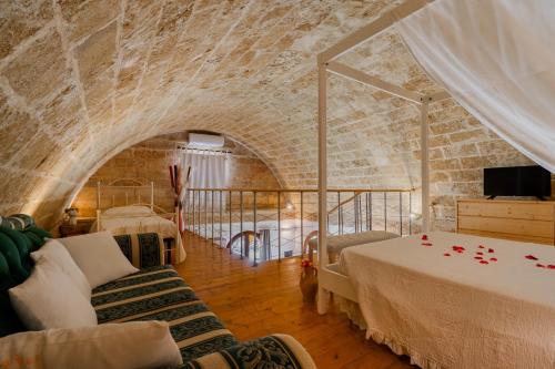 a room with two beds and a brick wall at Dimora Soleda in Torre San Giovanni Ugento