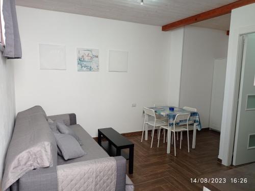 a living room with a bed and a table with chairs at Sea House Kamaraton in Marina di Camerota