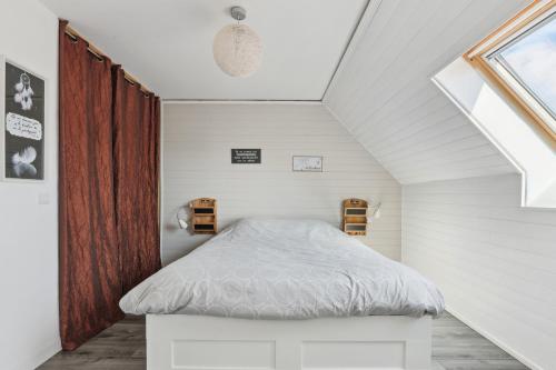 ein kleines Schlafzimmer mit einem Bett im Dachgeschoss in der Unterkunft Le Lussac - Saint Cyr in Saint-Cyr-lʼÉcole